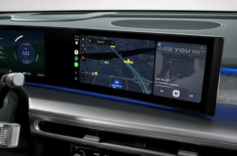 Car dashboard displaying navigation and music apps on digital screens.
