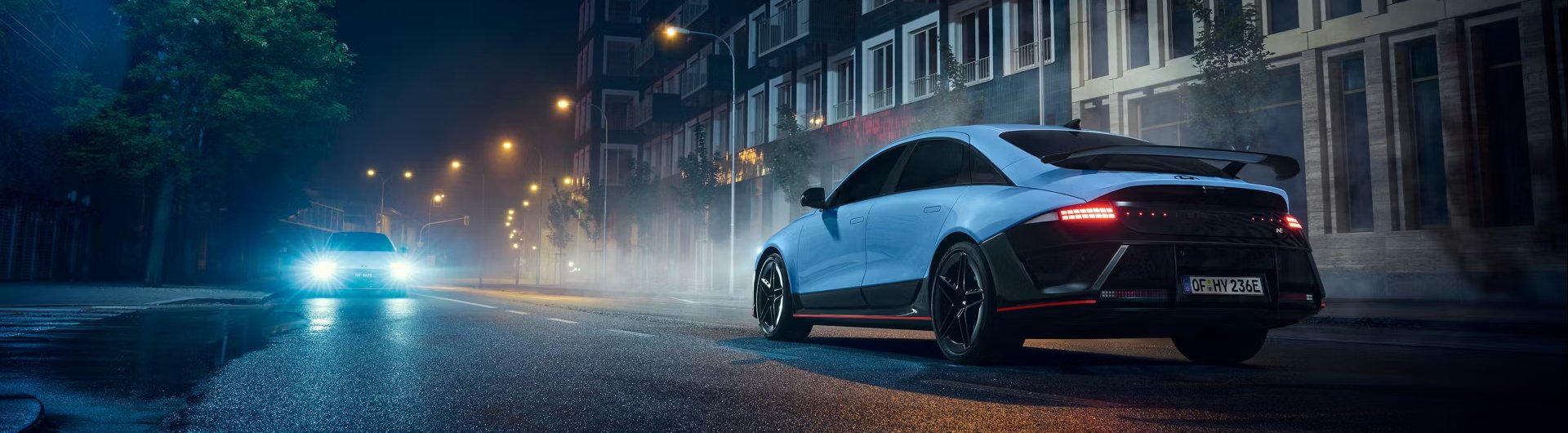 car parked in a street at night time with headlights pointing in that direction