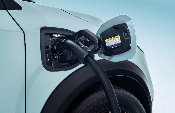 Electric vehicle charging with a cable plugged into the port on a car.