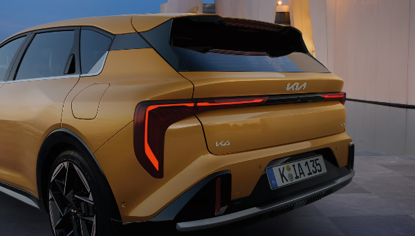 Rear view of a gold Kia SUV, showcasing the tail lights and rear spoiler.