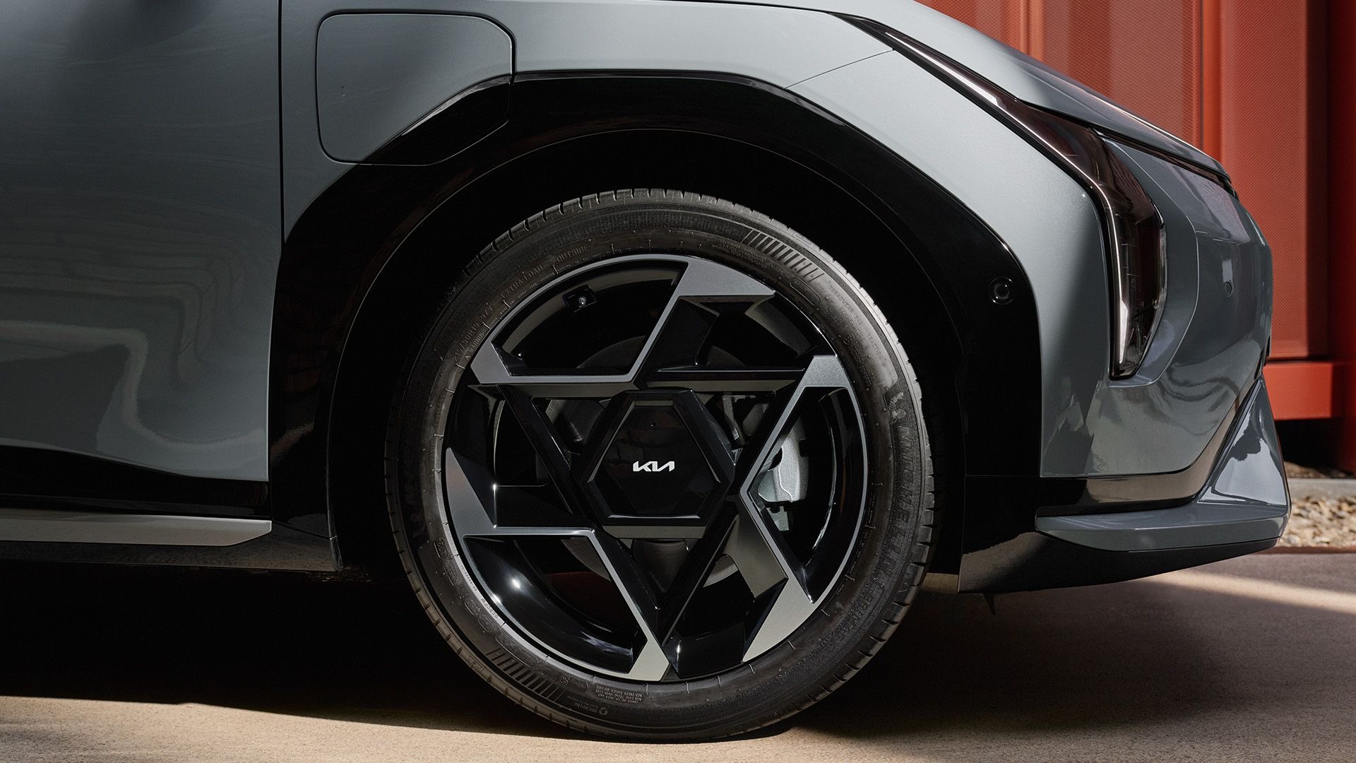 Close-up of a car wheel with a geometric black alloy design.