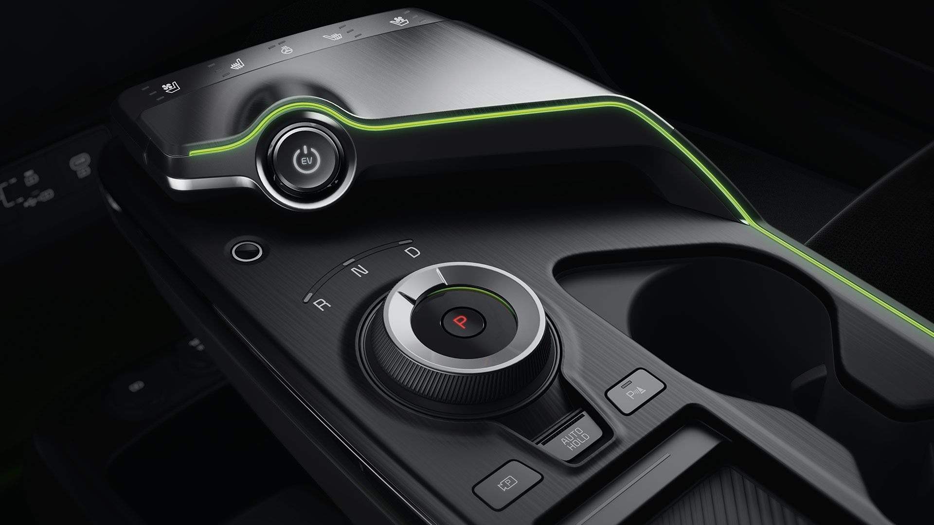 Close-up of a car's gear selector dial and electronic controls in the centre console.