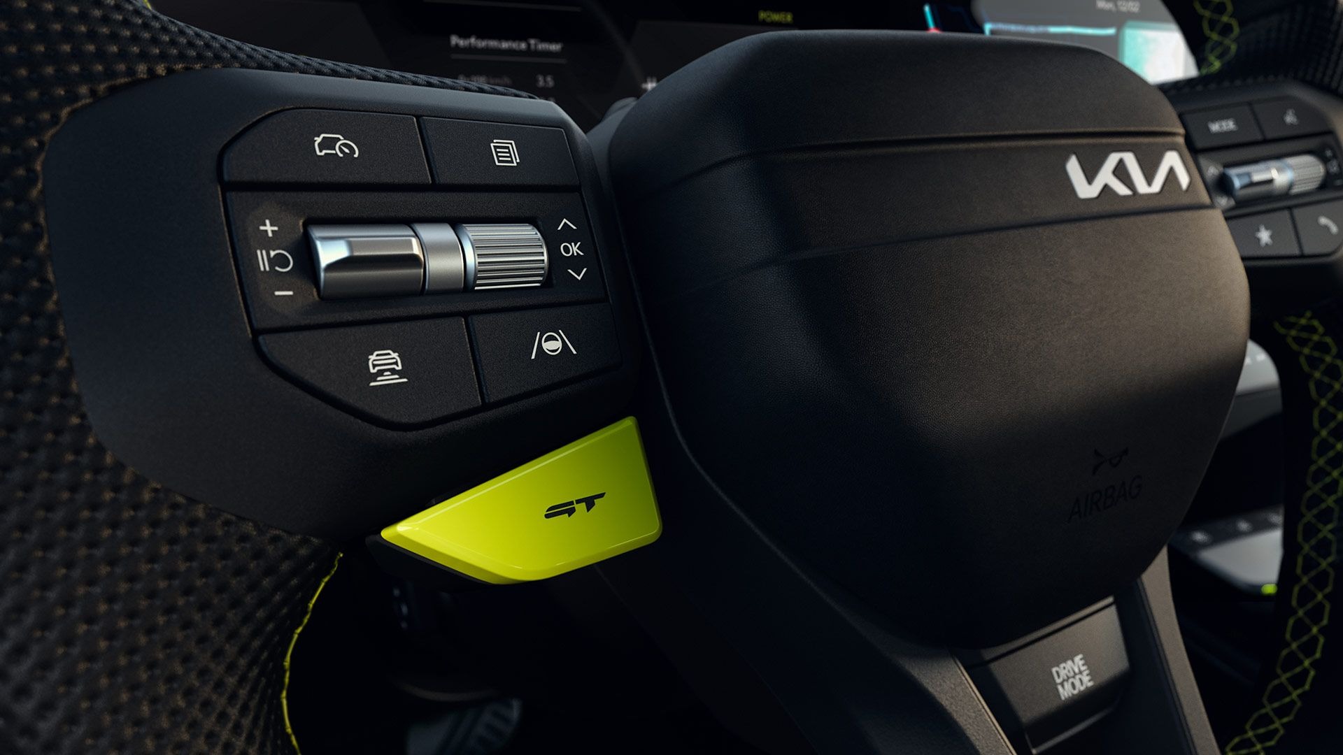 Close-up of a car steering wheel with control buttons and a yellow accent.