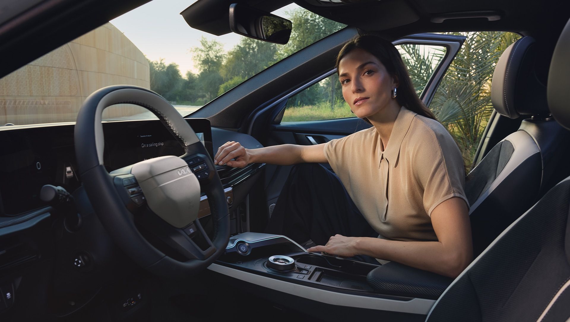 Person seated inside a car, adjusting the dashboard controls.
