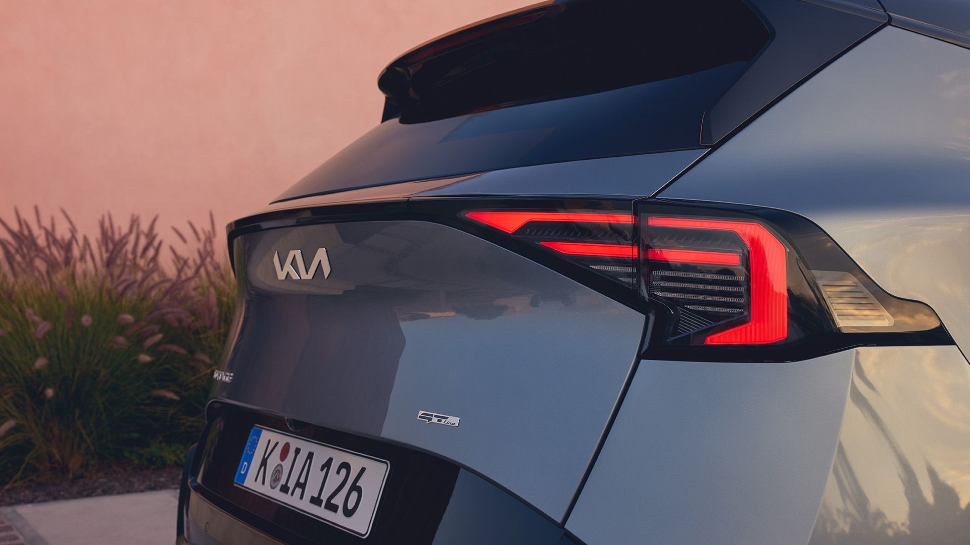 Close-up of a car's rear with a Kia badge and modern taillight design.