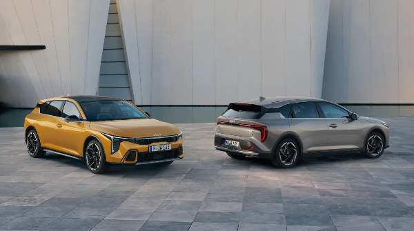 Two cars, one yellow and one grey, parked on a paved surface.
