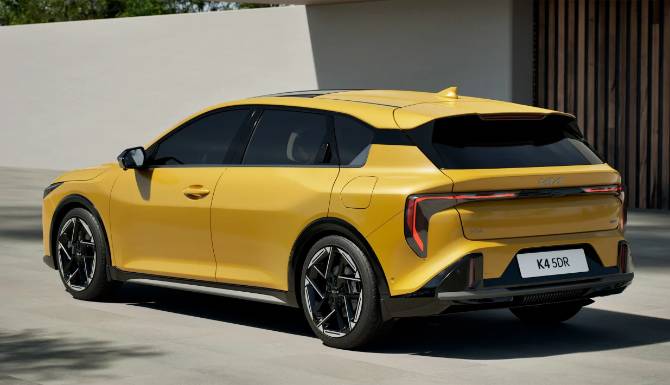 Yellow electric SUV with black roof, rear view, parked on concrete surface.