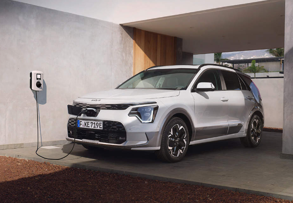White electric SUV charging at a home station.