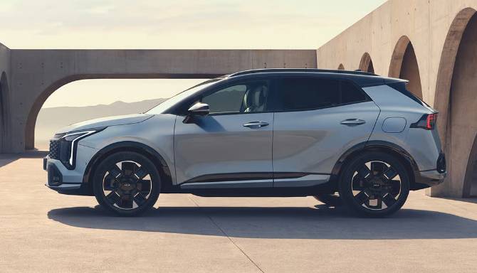 Side view of a silver SUV parked in front of an arched concrete structure.