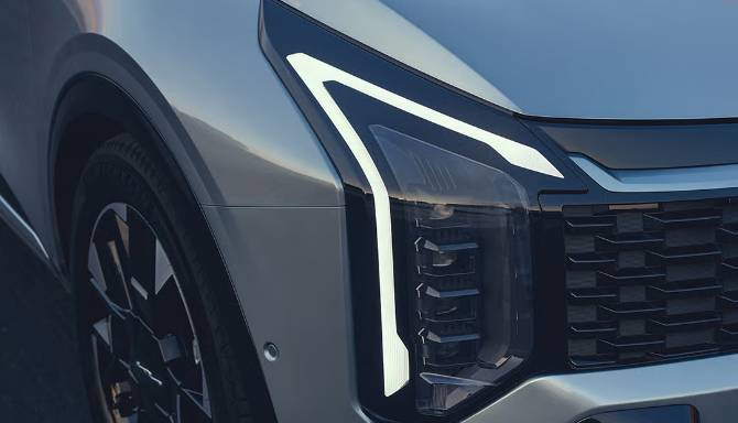 Close-up of a car's front headlight and grille with a modern design.
