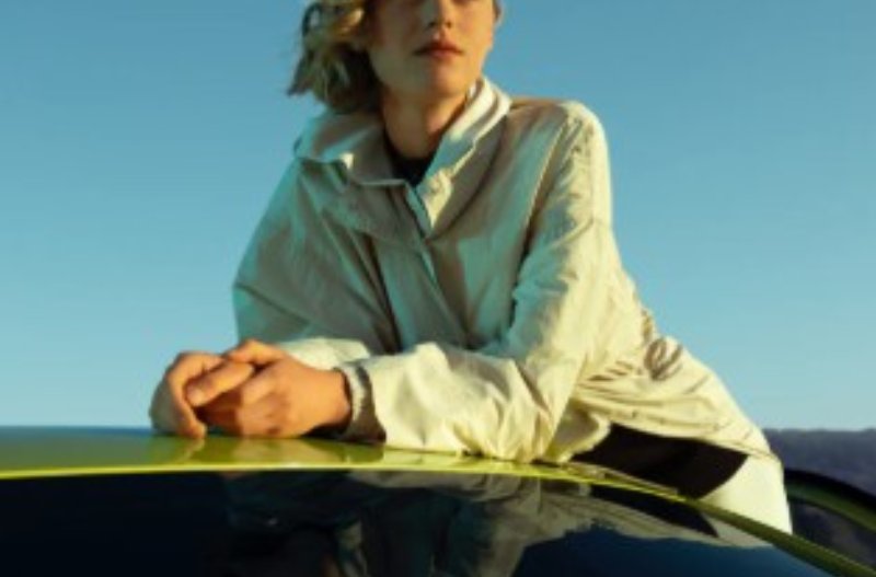 Lady leaning on the roof of the 208