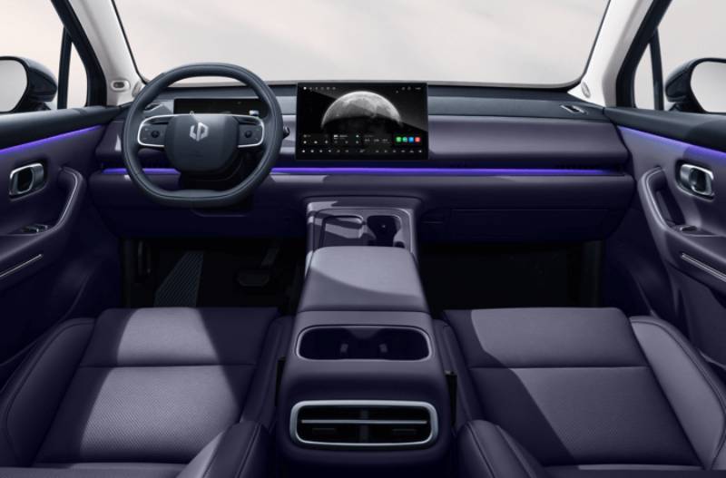 Interior of a car with a digital display, steering wheel, and central console.