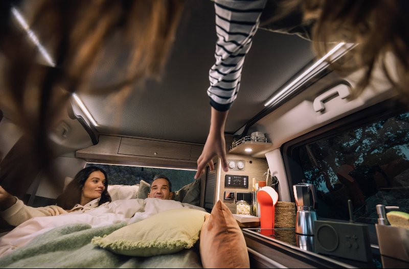 man and woman laid in the bed of the citroen holidays