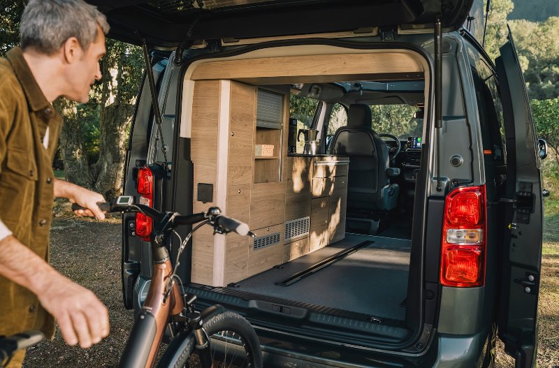 man loading bike into citroen holidays van rear