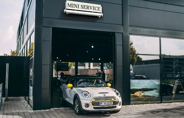White Mini Cooper exiting a service centre.