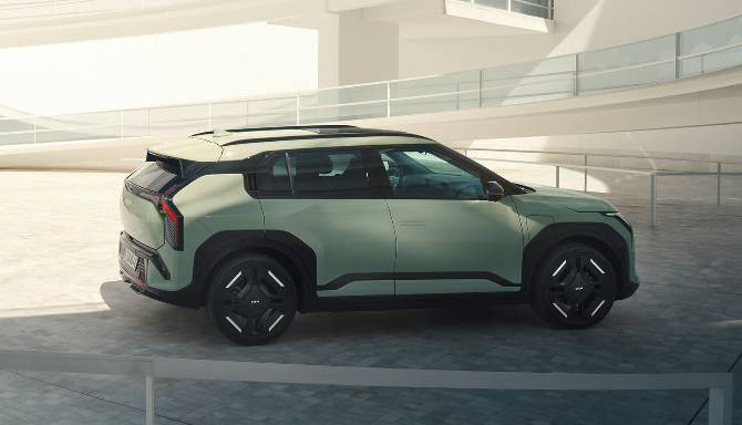 Green SUV viewed from the side, parked in a sunlit area.