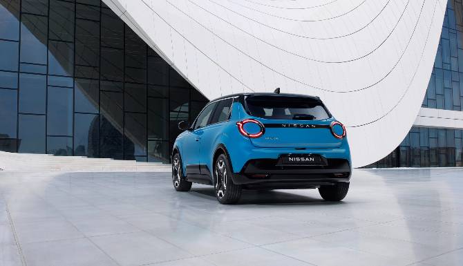 Blue Nissan car parked on a modern paved surface in front of a large glass and white structure.