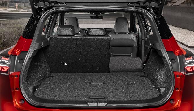 Open boot of a red car showing rear seats and spacious storage area.