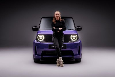 Person leaning against a purple car, facing forward.