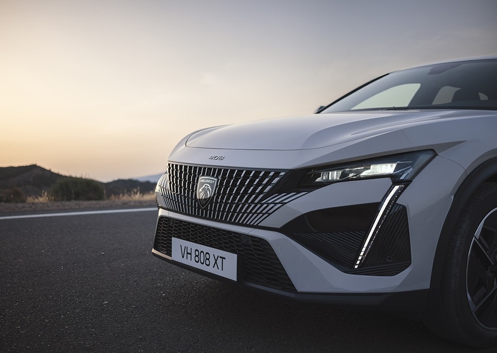Close-up of the front of a 2023 Peugeot 408 parked on a road.