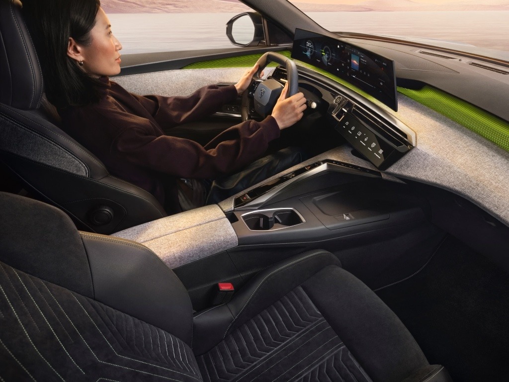 Person driving a car with a modern digital dashboard.