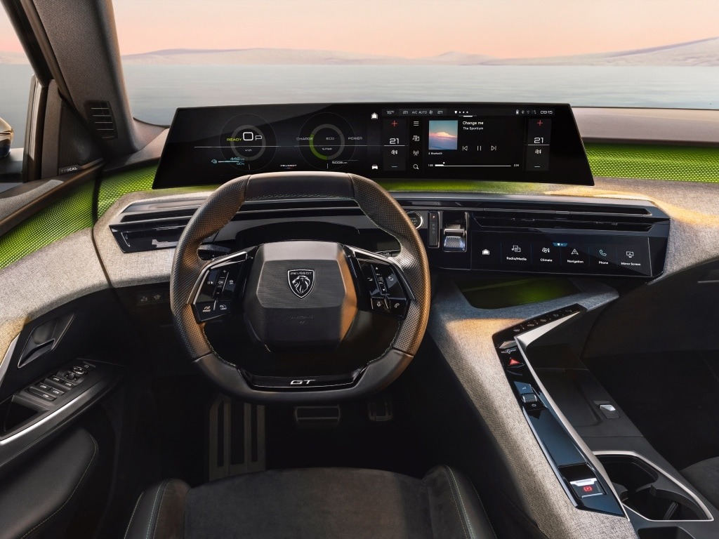 Car interior showing steering wheel and digital displays.
