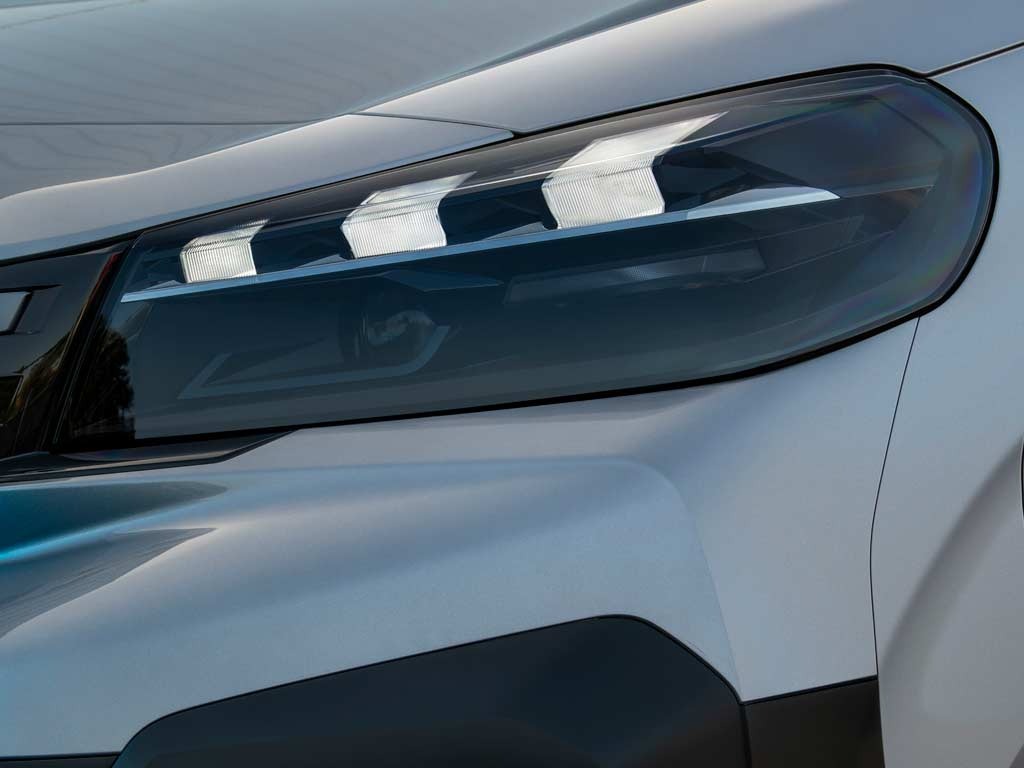 Close-up of a vehicle's headlight and front corner.
