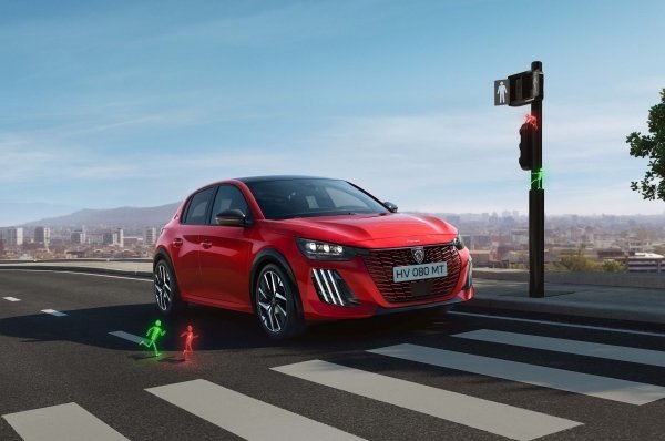 Red car on a zebra crossing with animated green pedestrian lights on a sunny day.