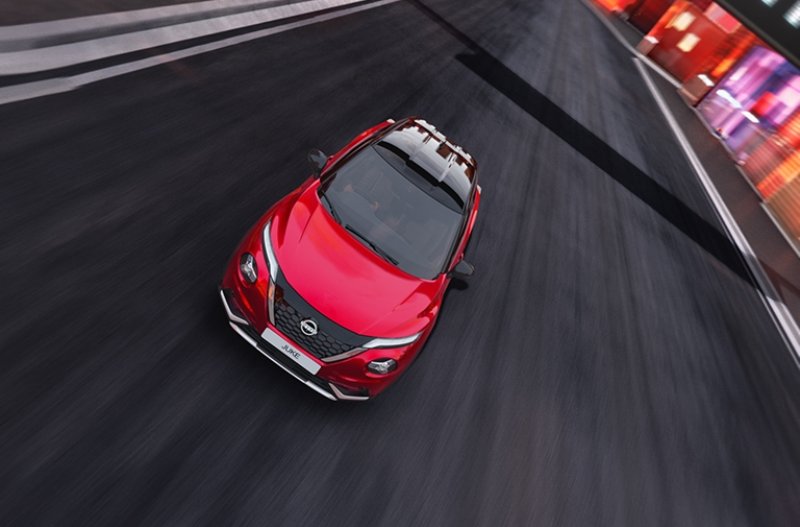 Red car driving on a road from an elevated view.