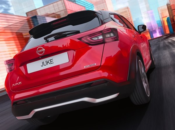Red SUV with 'Juke' badge driving through a colourful urban area.