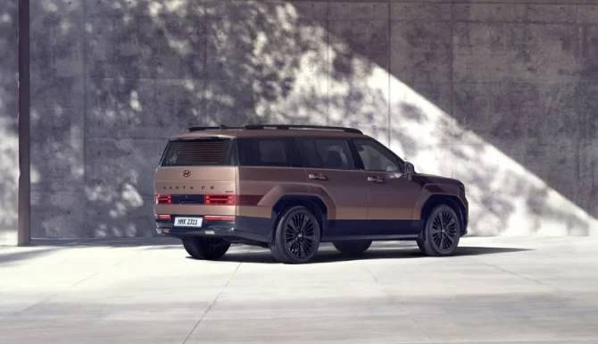 Brown SUV parked on a concrete surface with shadows on the wall.