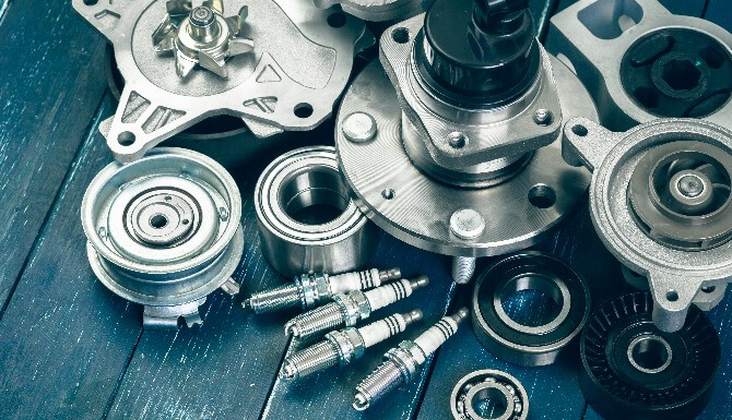 Various automotive parts including bearings and spark plugs.