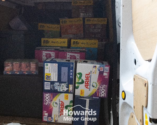 Inside of van loaded with various boxed grocery items and cleaning products.
