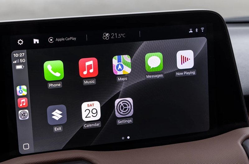 Close-up of a car infotainment display showing app icons and Apple CarPlay interface.