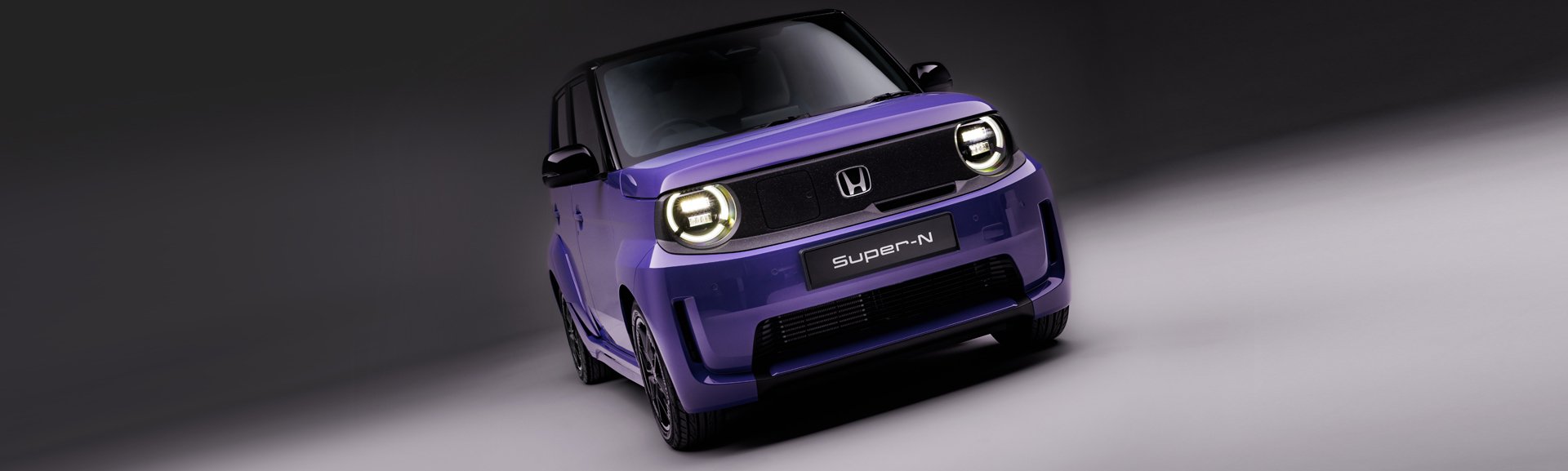 Purple Honda Super-N car with round headlights, viewed from the front.