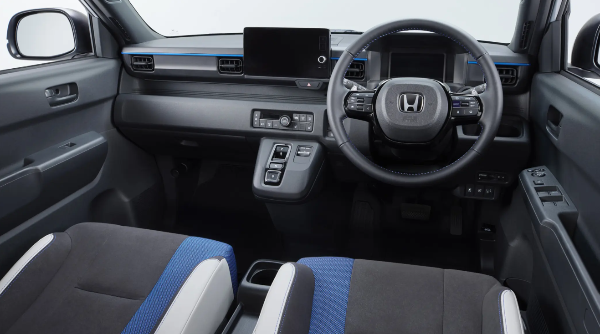 Car interior with steering wheel, dashboard controls, and blue-accented seats.