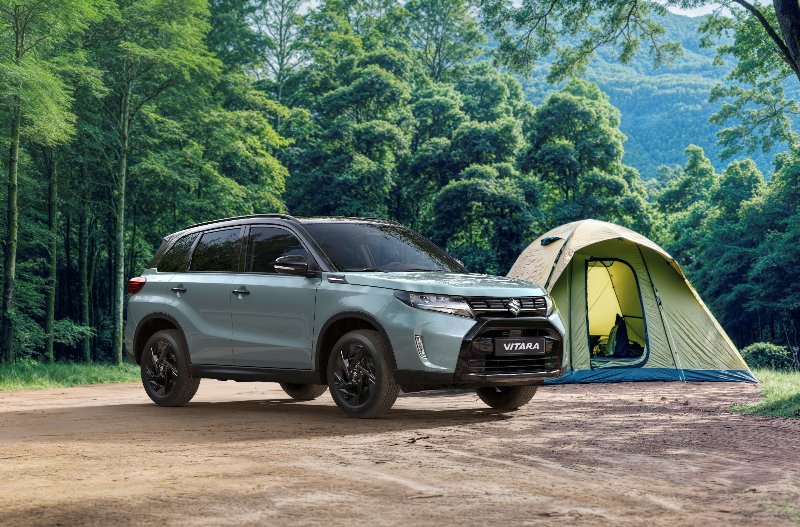 SUV parked next to a tent in a forested area.