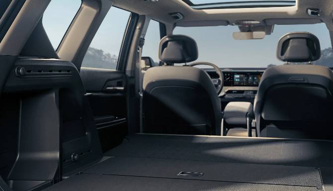 Interior view of a car with rear seats folded down, showing the dashboard and sunroof.