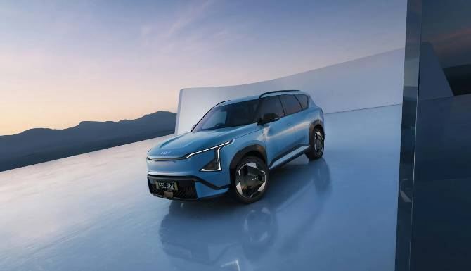 Blue SUV parked on a glossy surface with a mountain backdrop.