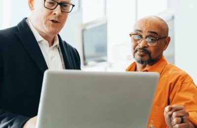 Two men looking at a laptop screen