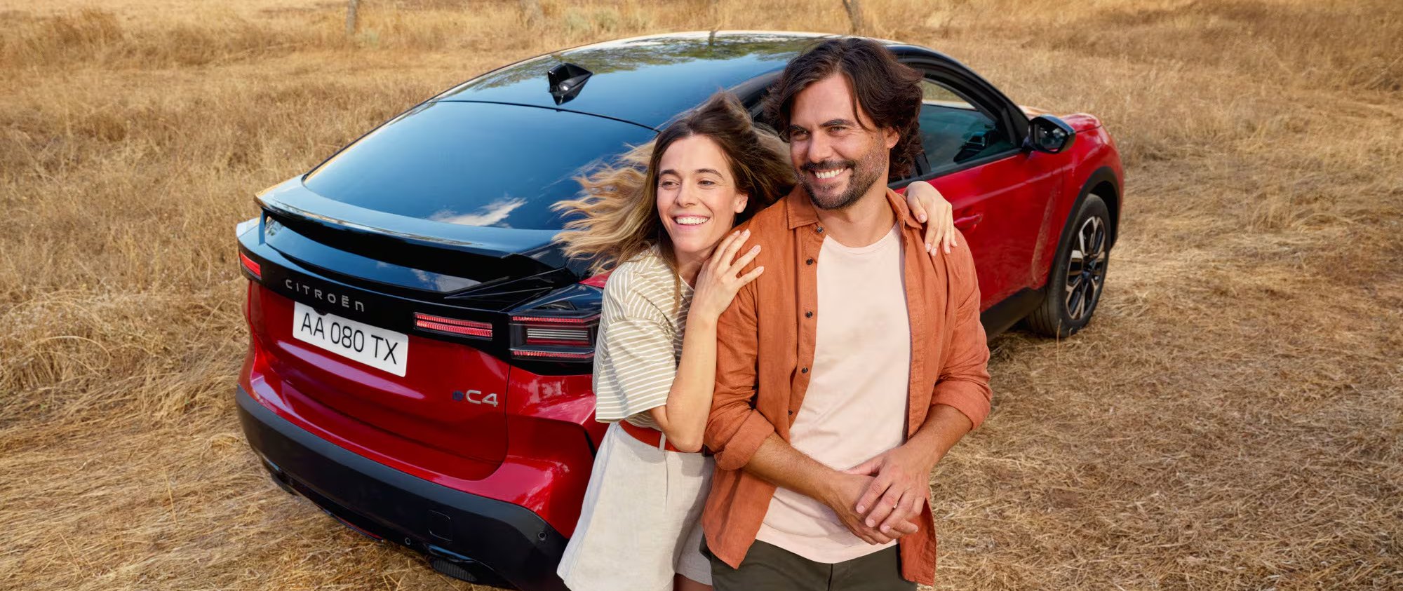 two people stood next to the red car