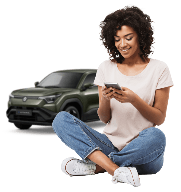 Woman on phone with Suzuki e-vitara behind