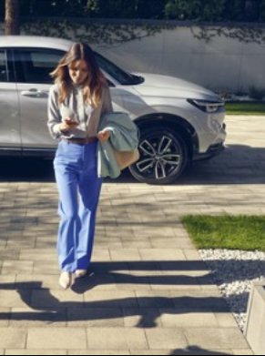 Woman walking away from a white honda