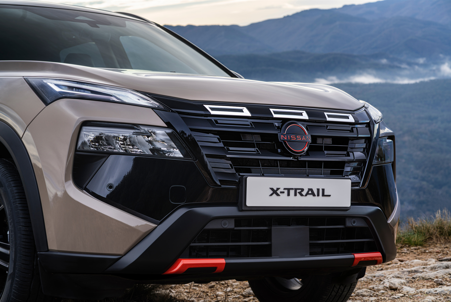 Front view of a Nissan X-Trail car with a visible badge and grille design.