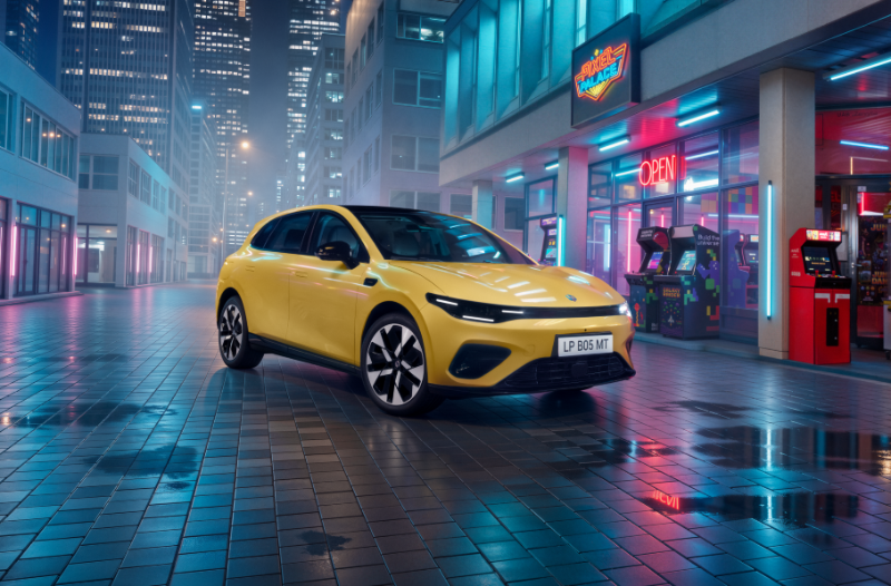 Yellow electric car parked near illuminated arcade machines at night.